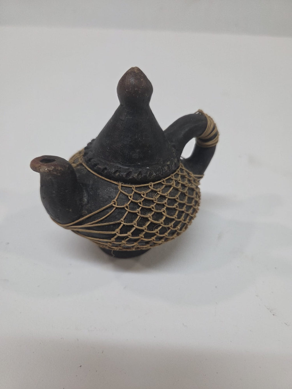 Tetera Artesanal Miniatura de Barro Negro y Red de Fibra Natural – Pieza Etno-Decorativa